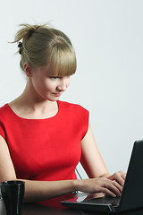 Image showing Businesswoman in red working on laptop