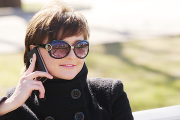 Image showing Smiling woman in black with cellphone