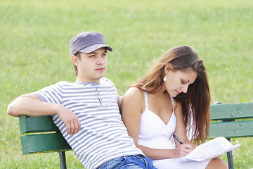 Image showing Couple sitting on bench in summer