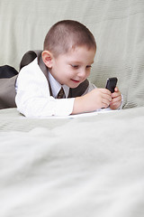 Image showing Little boy looking at cellphone