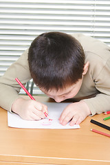 Image showing Boy inclining over drawing