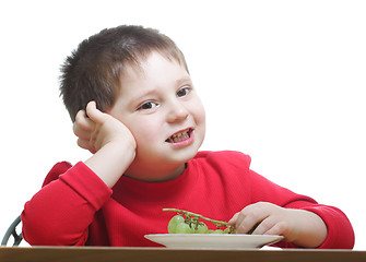 Image showing Cute boy in red eating grapes