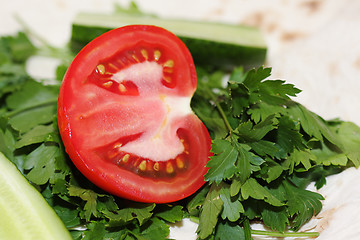 Image showing Sliced tomato on greens