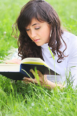 Image showing Serene brunette reading book on grass
