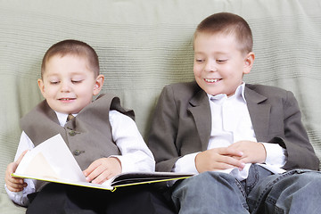 Image showing Smiling brothers reading book
