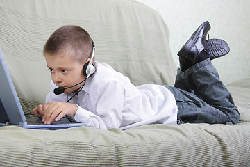 Image showing Boy in headset working on laptop