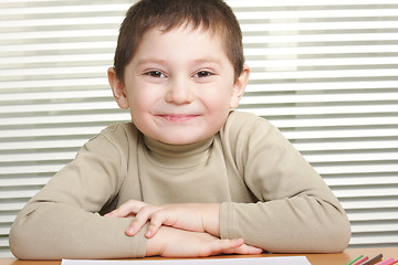 Image showing Smiling boy at desk