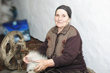Image showing Senior woman carding woollen yarn