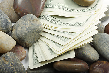 Image showing Money among pebbles