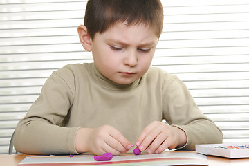 Image showing Boy modelling at desk