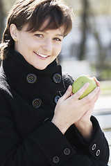 Image showing Smiling woman in black with apple