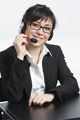 Image showing Positive businesswoman with headset sitting at desk