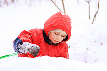 Image showing Little kid in red jacket playing in snow