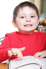 Image showing Funny boy in red pointing to book page