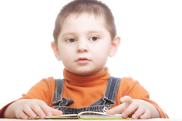 Image showing Thoughtful boy sitting with open book