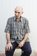 Image showing Serious elderly man sitting on chair