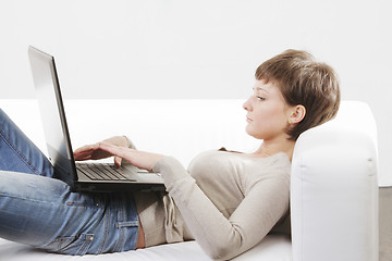 Image showing Woman laying on back with laptop