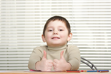 Image showing Smiling boy showing both thumbs up