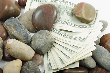 Image showing Dollars among pebbles