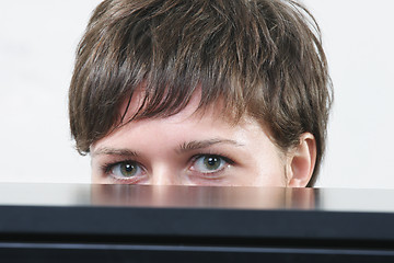 Image showing Woman hiding behind desk
