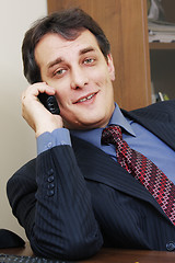 Image showing Businessman with phone inclining right