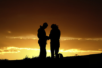 Image showing Two people silhouetted against dramatic skyline