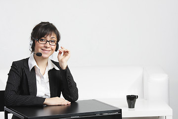 Image showing Businesswoman with headset at empty desk