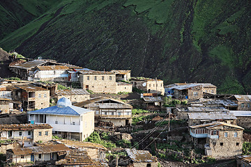 Image showing Village against dark mountain