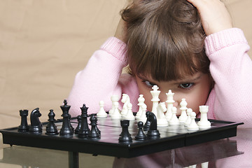 Image showing Girl thinking over chess