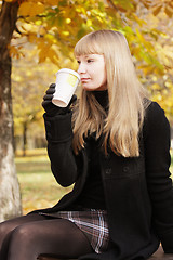 Image showing Blonde in black drinking from cup