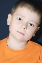 Image showing Boy in orange bending head