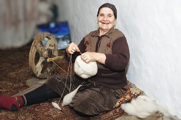 Image showing Smiling senior winding up thread into clew