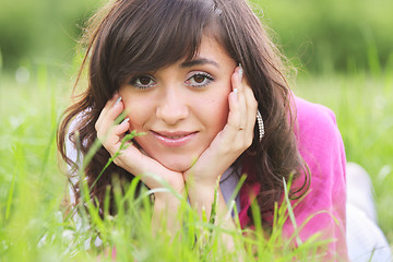 Image showing Brunette in grass leaning on hands