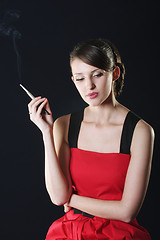 Image showing Thoughtful woman in red smoking