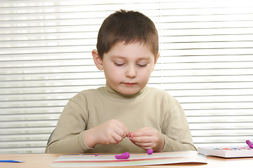 Image showing Boy modelling with plasticine