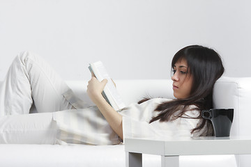 Image showing Brunette with book laying down on back