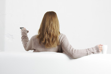 Image showing Blonde with remote control rear view