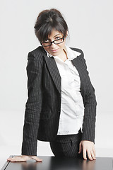 Image showing Brunette businesswoman looking over glasses