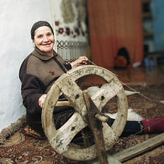 Image showing Smiling senior working on loom