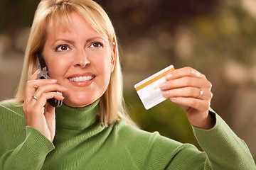 Image showing Cheerful Woman Using Her Phone with Credit Card