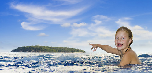 Image showing girl in the sea pointing to an island