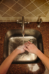 Image showing Overview of hand washing over a stainless steel sink