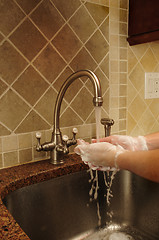 Image showing Hand washing and rinsing soapy water at a sink