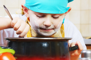 Image showing Little cook looking into pan