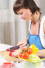 Image showing Woman cutting paprika sideview