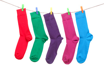 Image showing five different color socks hang on rope