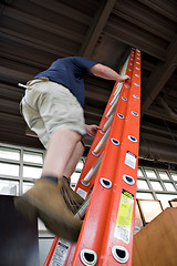 Image showing Man Climbing a Ladder