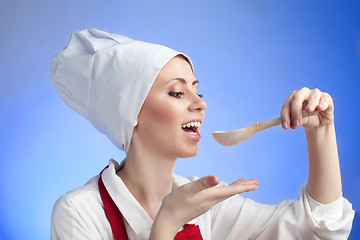 Image showing Cook tasting using wood spoon