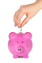 Image showing Hand putting coin in piggy bank