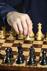 Image showing Hand moving pawn on chess board